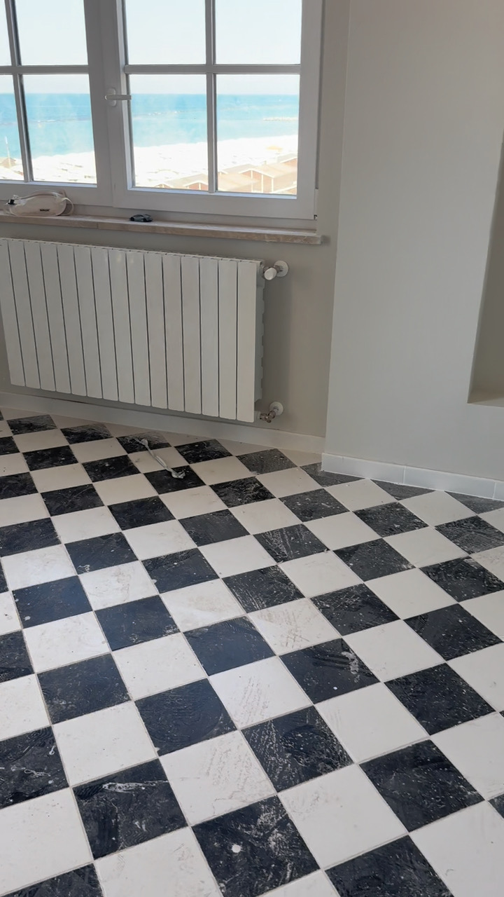 Appartamento con pavimento a scacchi bianco e nero dopo pulizia post-cantiere